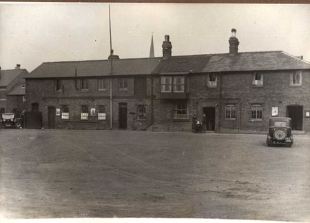 The Stores and Admin buildings - and the house in which William Pullinger lived - looking East from the parade ground with All Saints Church Spire in the distance taken in the 1920s.