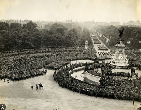 Marching troops pass the Queen Victoria Memorial outside Buckingham Palace