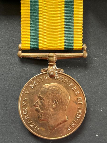 The obverse (front) of the Territorial Force War Medal, with a coloured ribbon recognising the forerunners of the Territorials: gold yellow representing the Imperial Yeomanry and green representing the Volunteer Force.