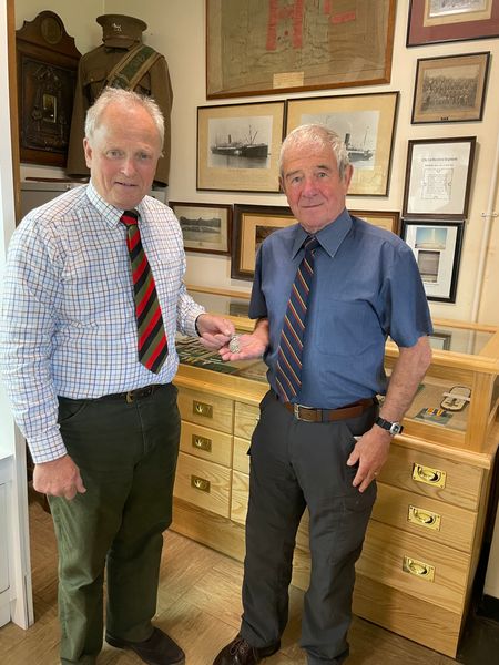 Barry Lindfield presents Cpl Bassett's medal to the Museum Curator.