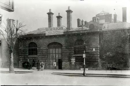 The main gate to the prison in Commercial Road after closure - advertising 'tours' for 6d.
