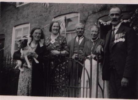 Harry, wearing his medals, with his family outside the family house in The Homend Ledbury - possibly in the 1930s at the Jubilee or Coronation.